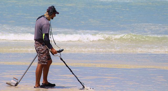 A person metal detecting on the beach